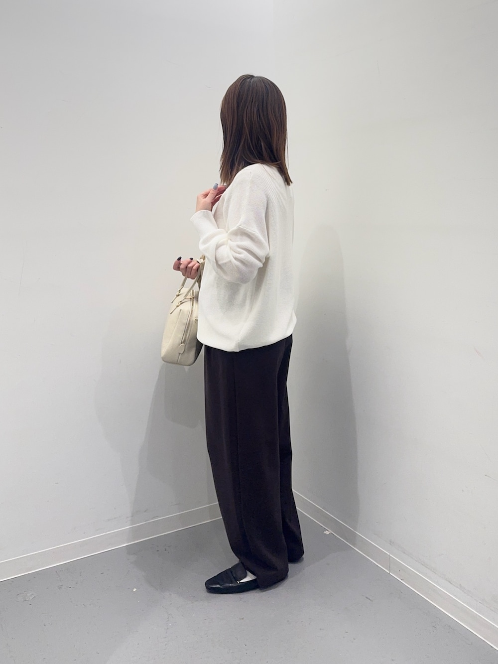 ホワイト系のニット/セーター、ベージュ系のナイロンジャケット、ブラウン系のその他パンツを着用したレディースの春コーディネートの5枚目の写真