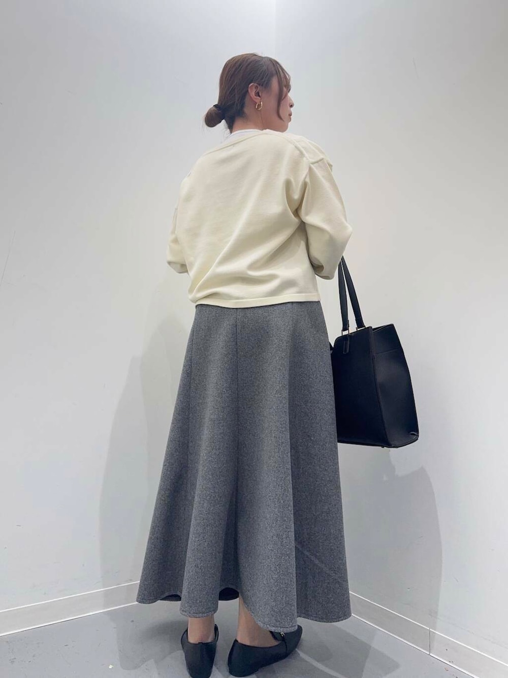 ホワイト系のカーディガン/ボレロ、グレー系のスカート、ブラック系のトートバッグを着用したレディースの冬コーディネートの4枚目の写真