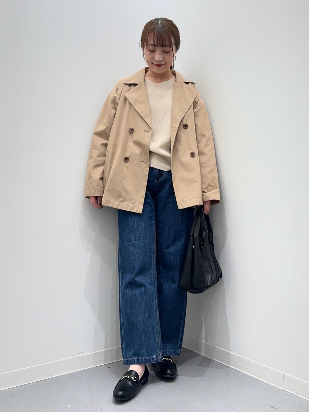 ホワイト系のニット/セーター、ベージュ系のその他アウター、ブルー系のデニムパンツを着用したレディースの春コーディネートの5枚目の写真