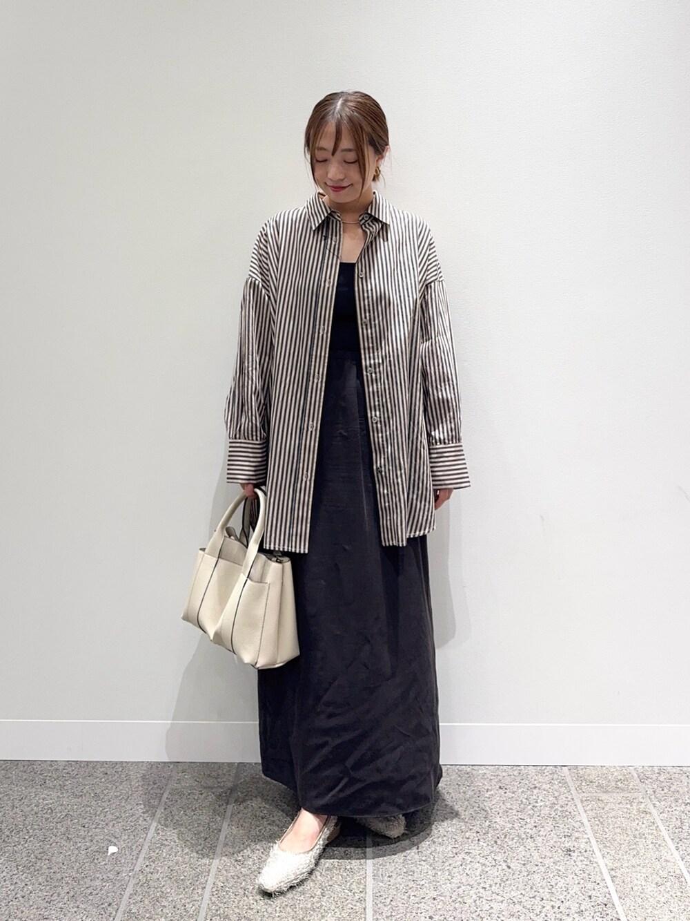 グレー系のシャツ/ブラウス、ブラウン系のスカート、ホワイト系のトートバッグを着用したレディースの秋コーディネートの5枚目の写真