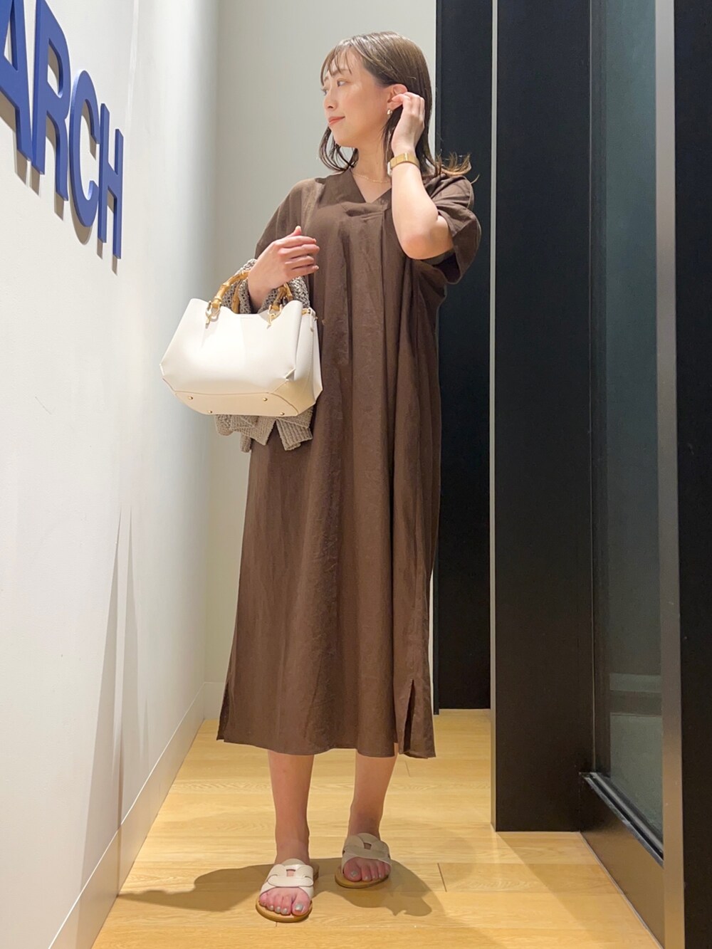 ブラウン系のワンピース、グリーン系のカーディガン/ボレロ、ホワイト系のサンダルを着用したレディースの夏コーディネートの3枚目の写真