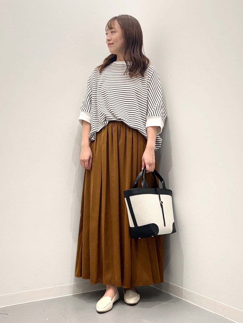 ホワイト系のTシャツ/カットソー、イエロー系のその他パンツ、ブラック系のトートバッグを着用したレディースの夏コーディネートの2枚目の写真