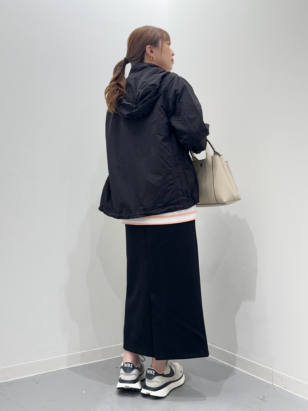 ピンク系のTシャツ/カットソー、ブラック系のマウンテンパーカー、ブラック系のスカートを着用したレディースの春コーディネートの4枚目の写真