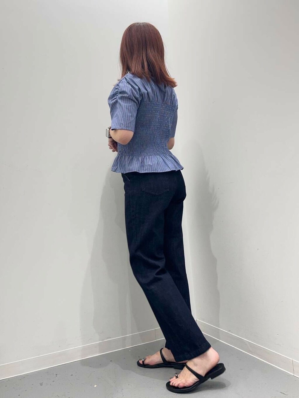 ブルー系のデニムパンツ、ブラック系のサンダル、ブラック系のトートバッグを着用したレディースの夏コーディネートの3枚目の写真