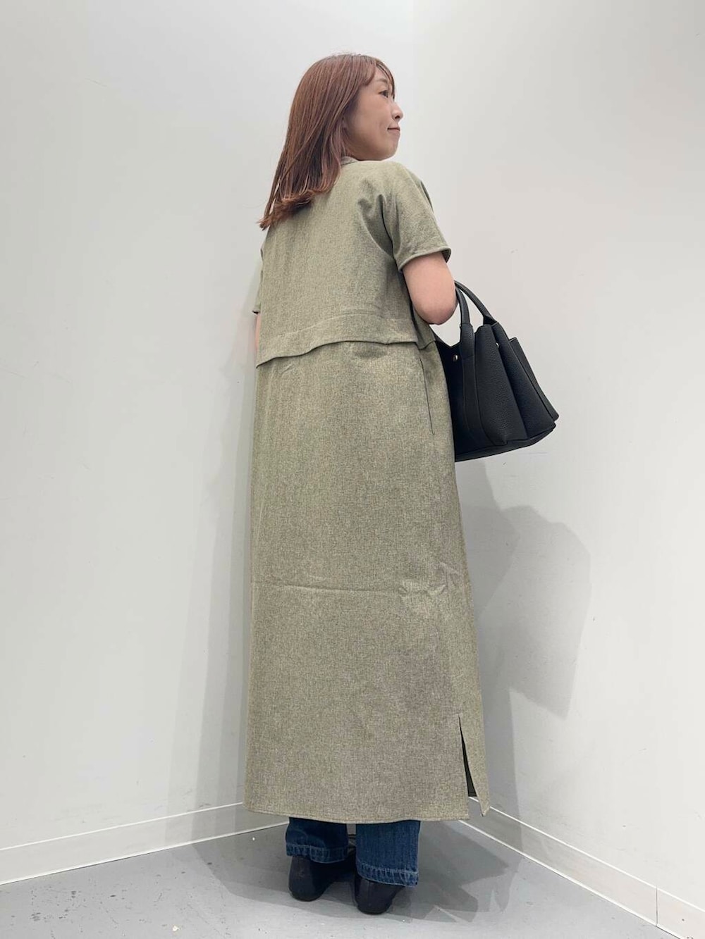 ブラック系のローファー、ブラック系のトートバッグ、ブルー系のデニムパンツを着用したレディースの夏コーディネートの4枚目の写真