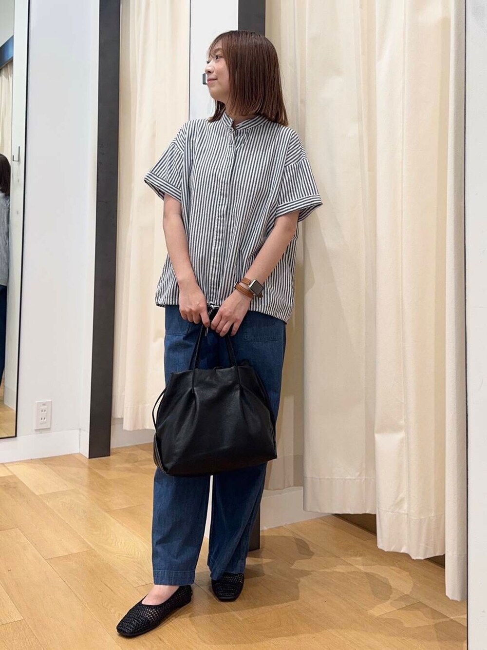 ブラック系のショルダーバッグ、ブルー系のデニムパンツ、ブラック系のバレエシューズを着用したレディースの夏コーディネートの5枚目の写真