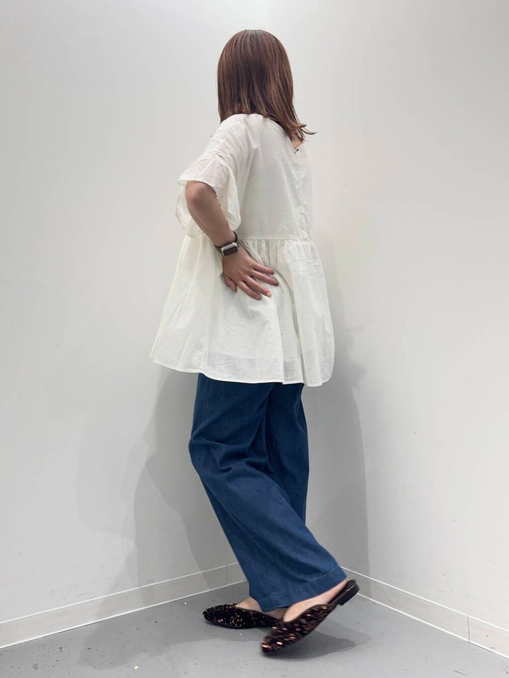 シルバー系のショルダーバッグ、ブルー系のデニムパンツ、ホワイト系のシャツ/ブラウスを着用したレディースの夏コーディネートの2枚目の写真