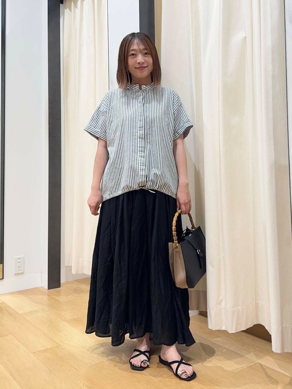 ブラック系のサンダル、ブラック系のハンドバッグ、ブラック系のスカートを着用したレディースの夏コーディネートの4枚目の写真