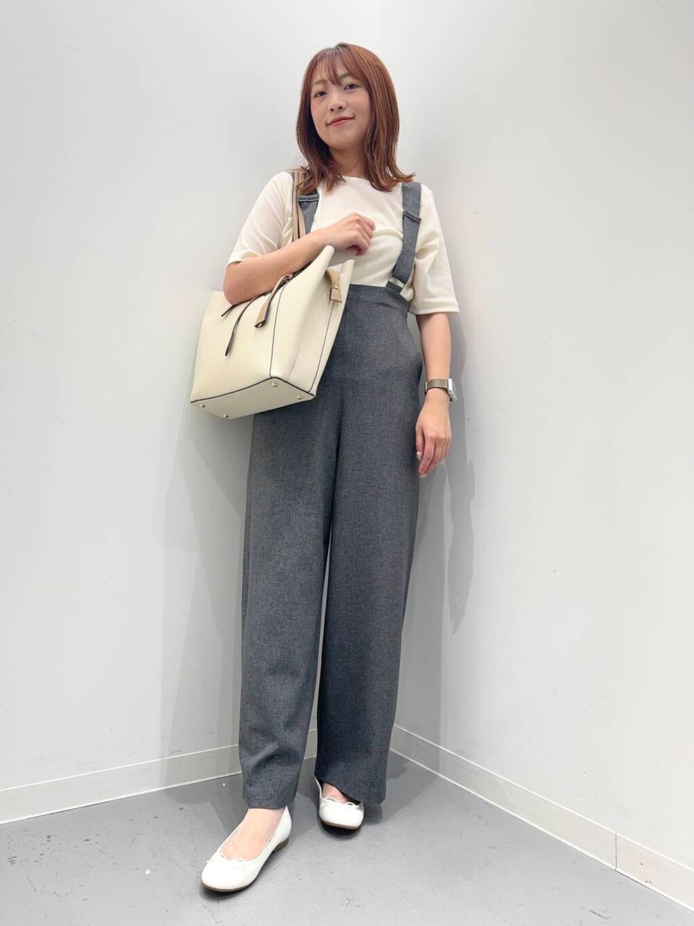 ホワイト系のトートバッグ、ホワイト系のバレエシューズ、グレー系のサロペット/オーバーオールを着用したレディースの夏コーディネートの2枚目の写真