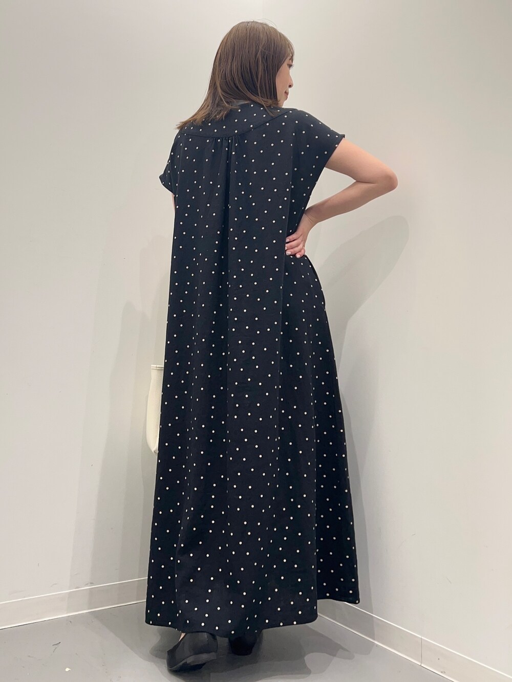 ブラック系のワンピース、ホワイト系のトートバッグを着用したレディースの春コーディネートの4枚目の写真