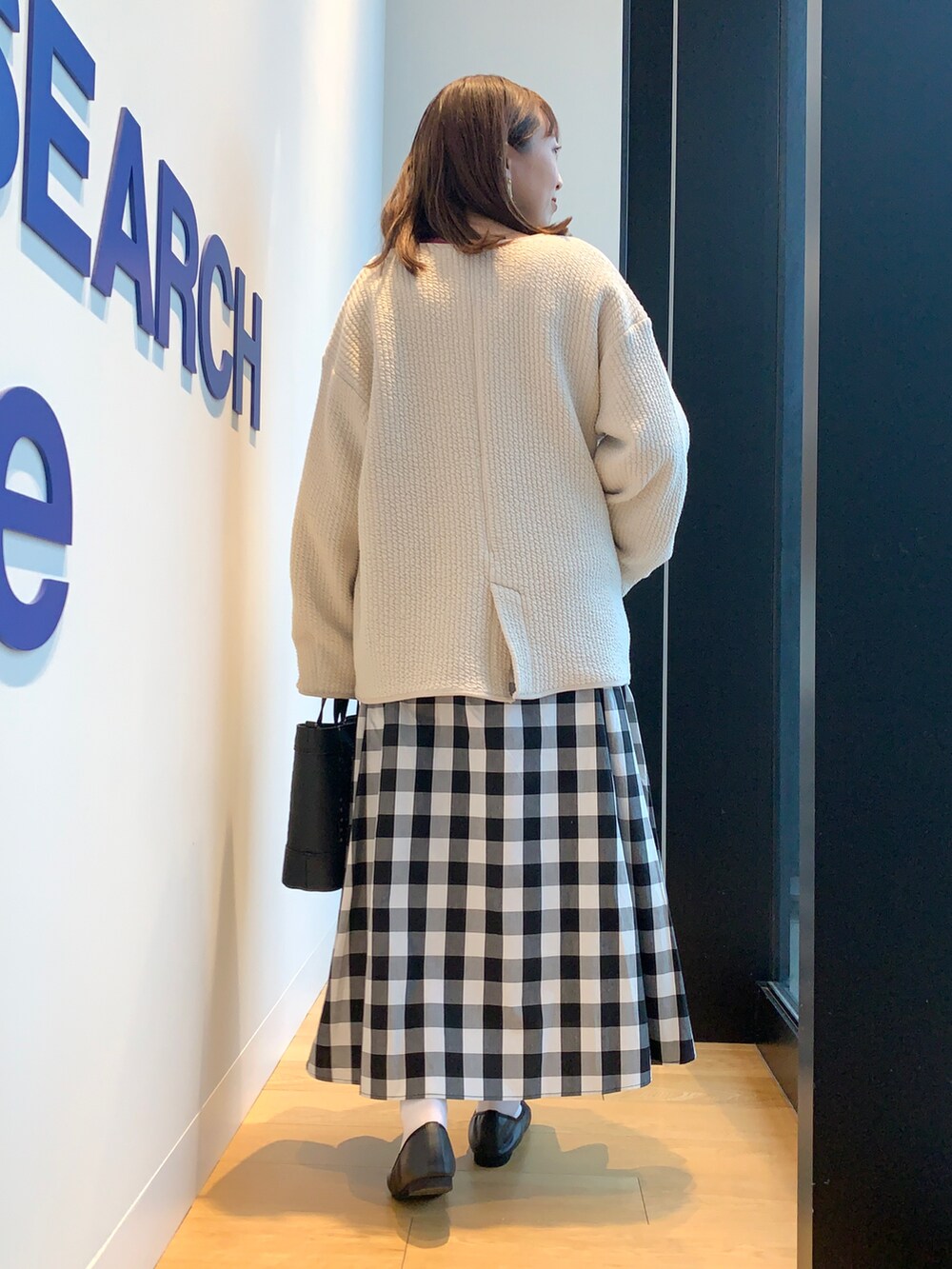 パープル系のニット/セーター、その他のスカート、ホワイト系のノーカラージャケットを着用したレディースの春コーディネートの3枚目の写真