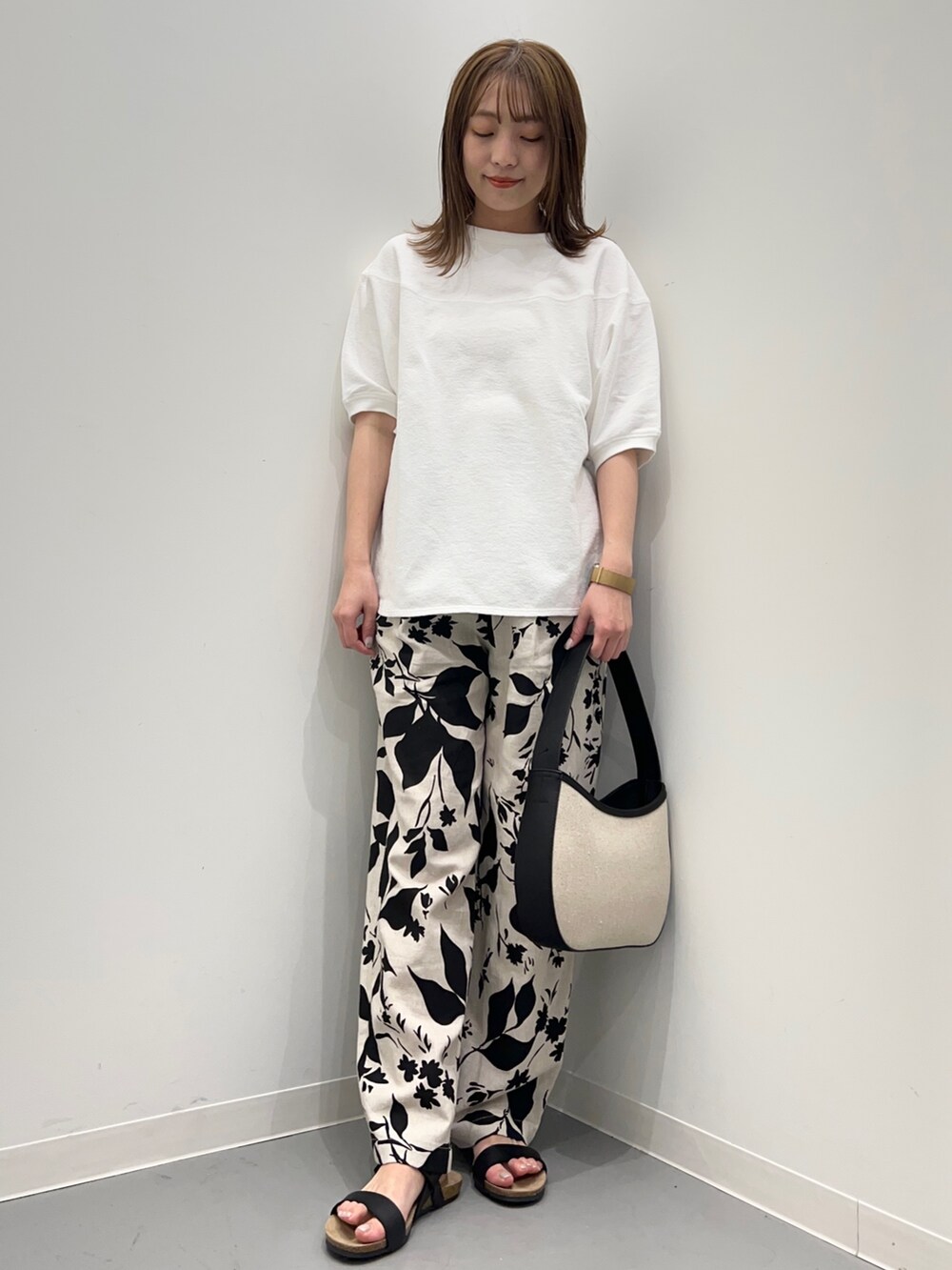 ホワイト系のTシャツ/カットソー、ベージュ系のその他パンツ、ブラック系のハンドバッグを着用したレディースの春コーディネートの5枚目の写真