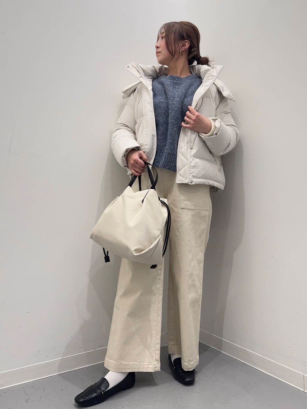 ブラック系のローファー、ホワイト系のショルダーバッグ、ホワイト系のダウンジャケット/コートを着用したレディースの冬コーディネートの2枚目の写真