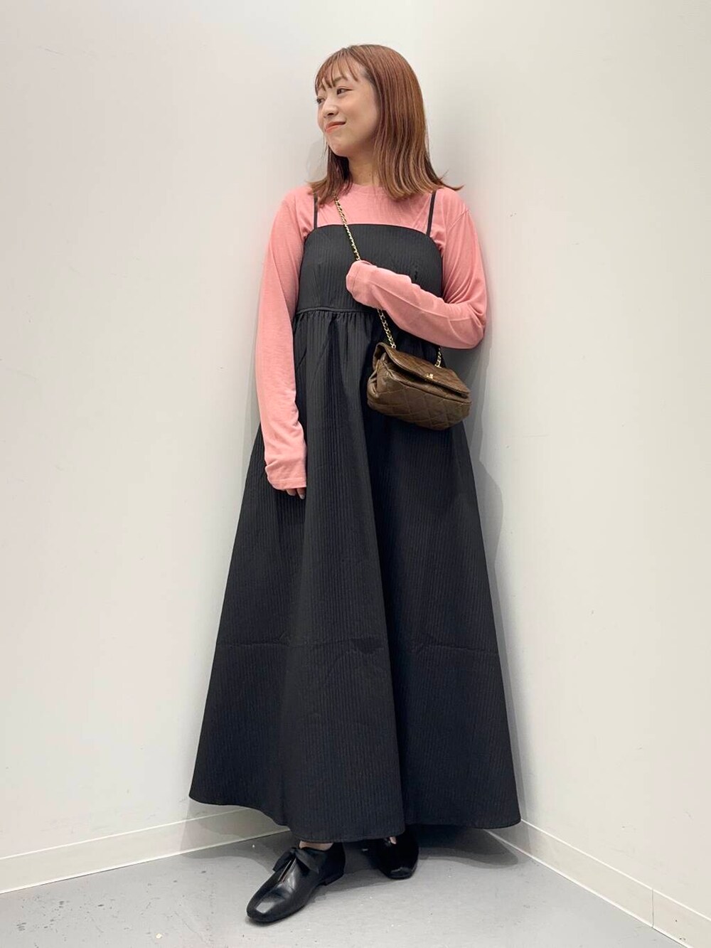 ブラウン系のショルダーバッグ、ピンク系のTシャツ/カットソー、ブラック系のワンピースを着用したレディースの夏コーディネートの5枚目の写真