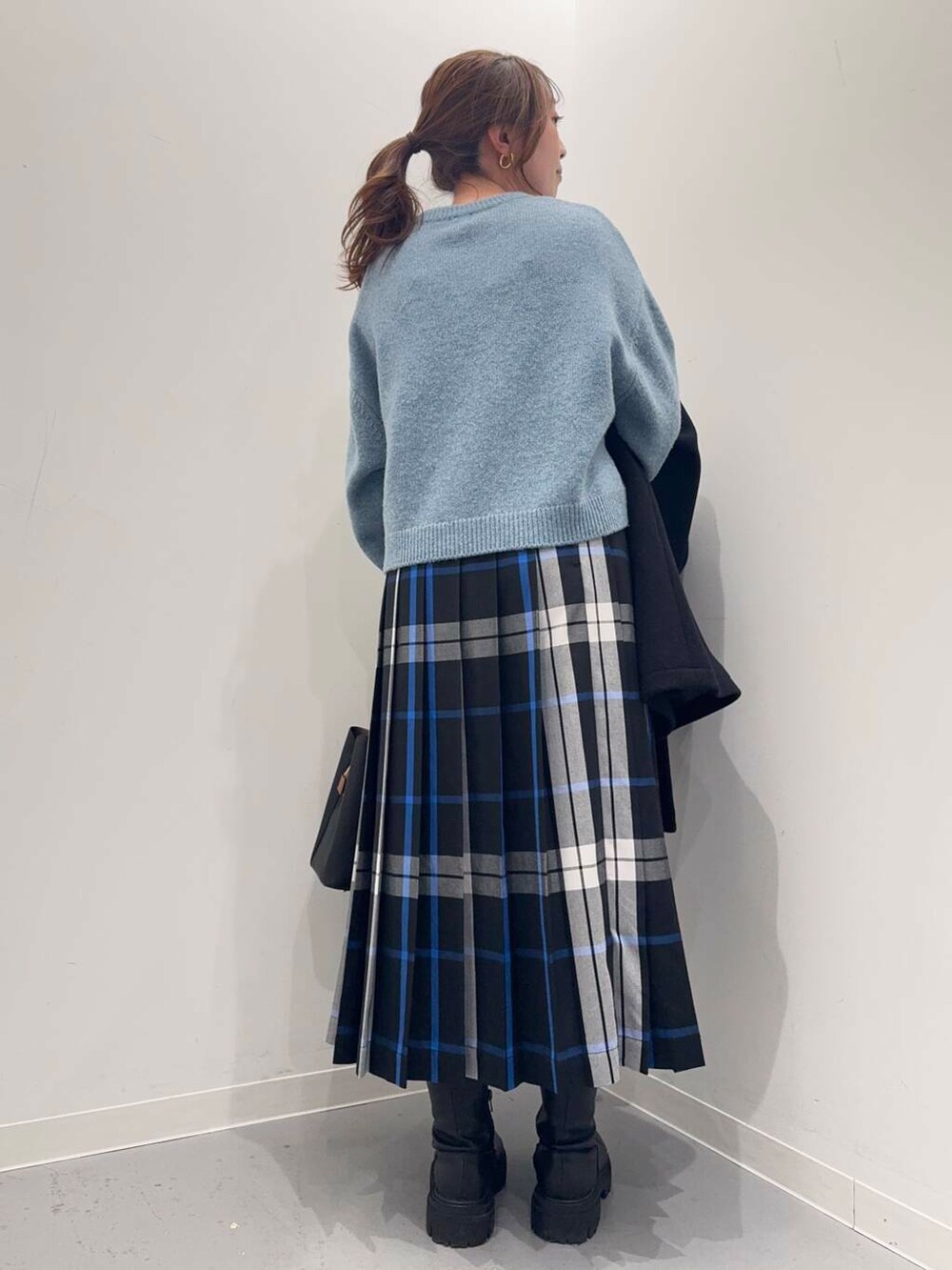 ブラック系のトートバッグ、ブラック系のその他アウター、ブラック系のブーツを着用したレディースの冬コーディネートの3枚目の写真