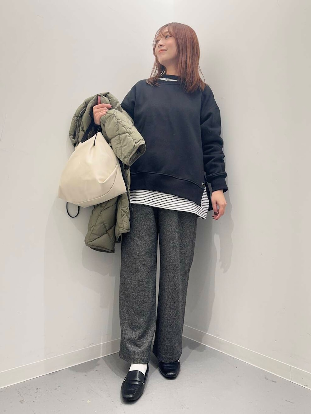 ブラック系のローファー、ホワイト系のショルダーバッグ、グリーン系のダウンジャケット/コートを着用したレディースの秋コーディネートの8枚目の写真