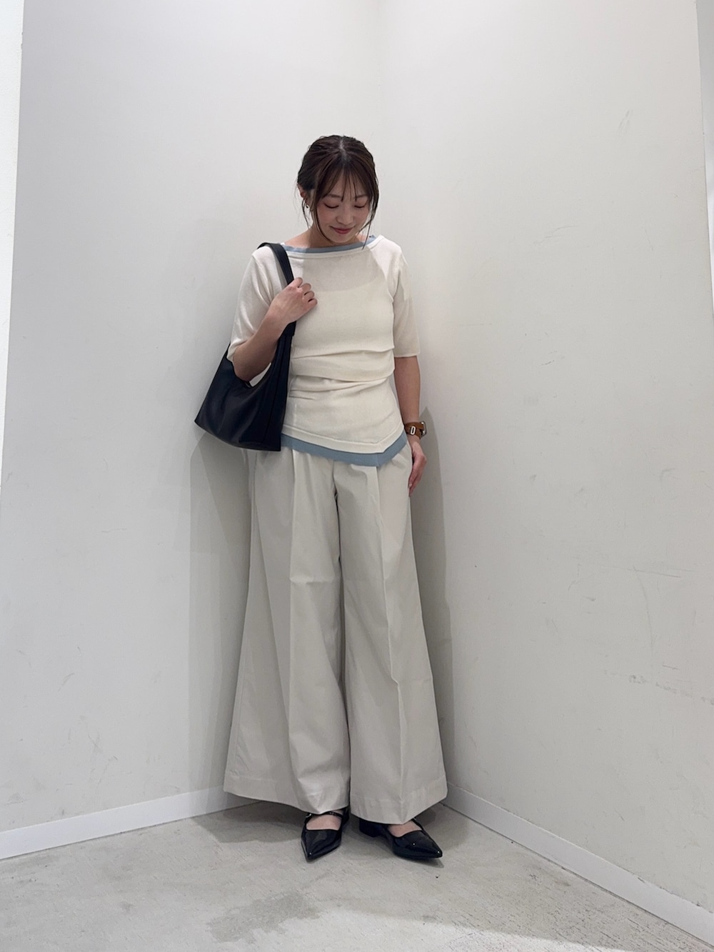 ホワイト系のニット/セーター、ホワイト系のチノパンツ、ブラック系のハンドバッグを着用したレディースの春コーディネートの3枚目の写真