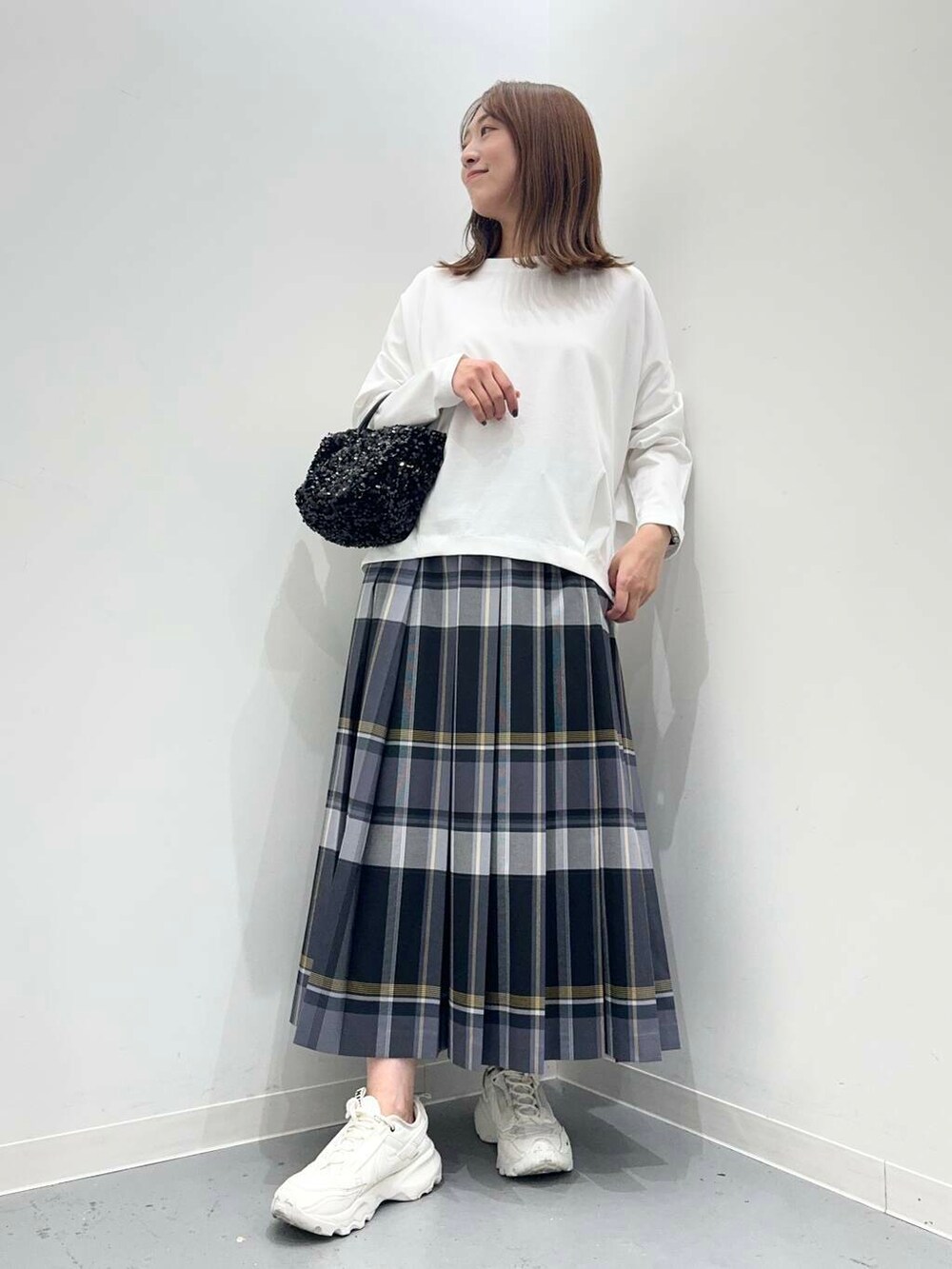ブラック系のショルダーバッグ、ホワイト系のスニーカー、ホワイト系のTシャツ/カットソーを着用したレディースの秋コーディネートの4枚目の写真