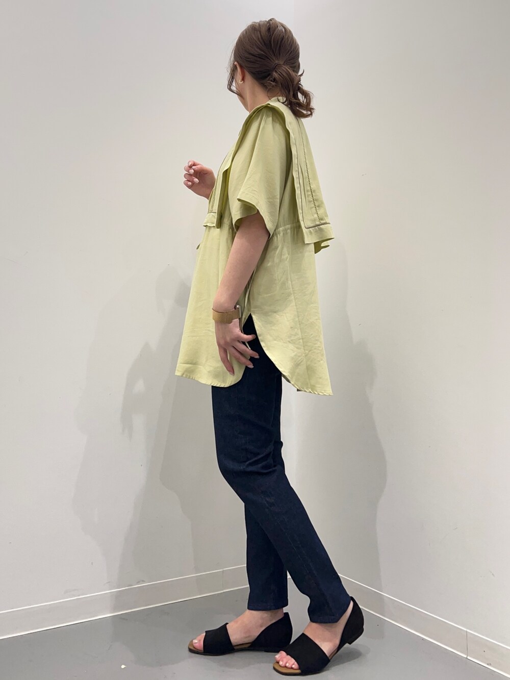 イエロー系のシャツ/ブラウス、ブルー系のデニムパンツ、ブラック系のショルダーバッグを着用したレディースの春コーディネートの5枚目の写真