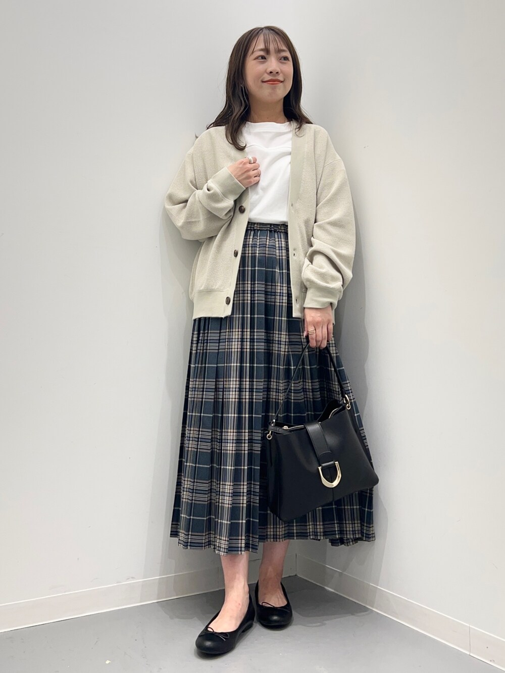 ホワイト系のトップス、ブルー系のスカート、ベージュ系のカーディガン/ボレロを着用したレディースの夏コーディネートの2枚目の写真