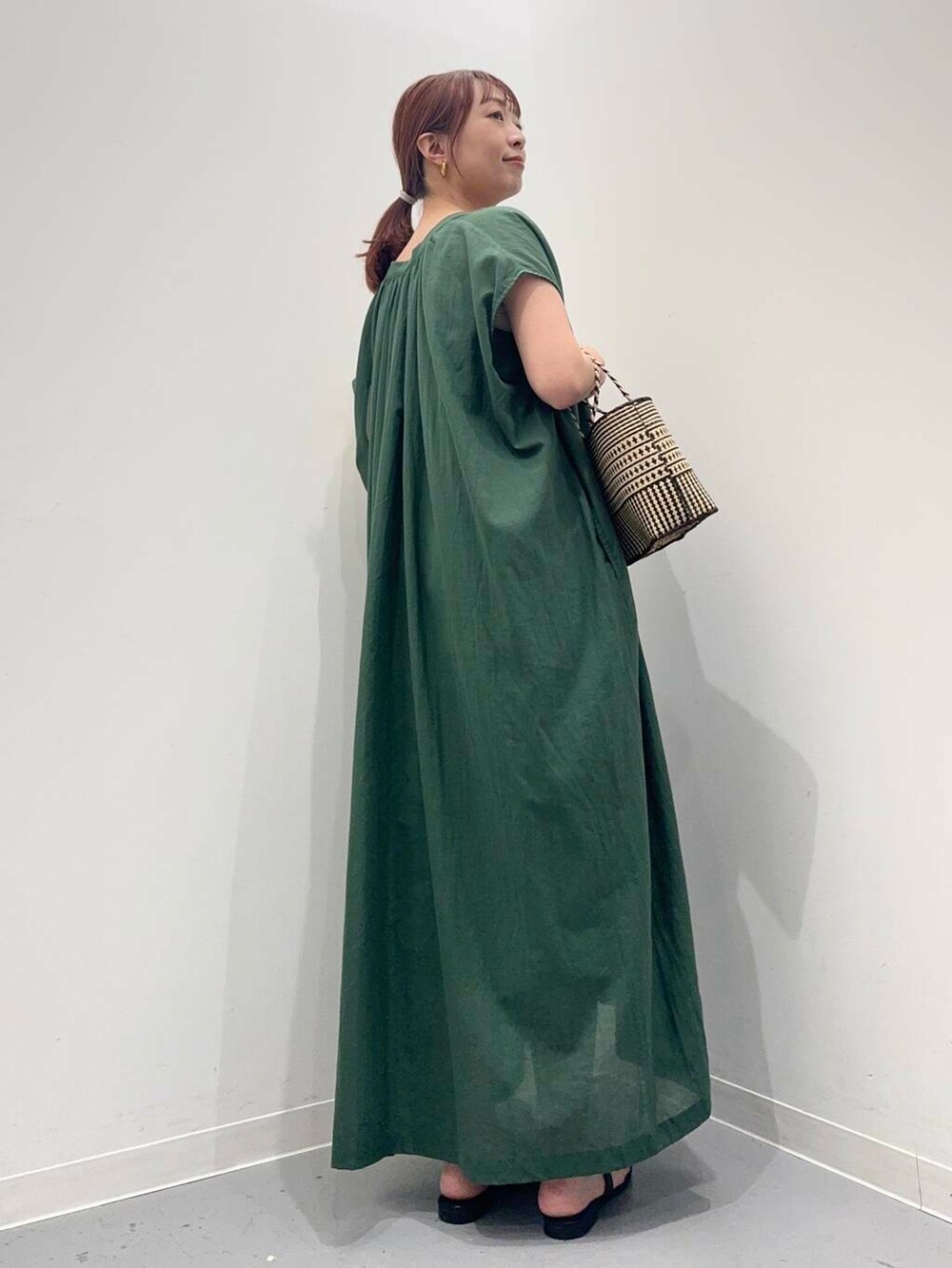 グリーン系のワンピース、ブラック系のサンダルを着用したレディースの夏コーディネートの4枚目の写真