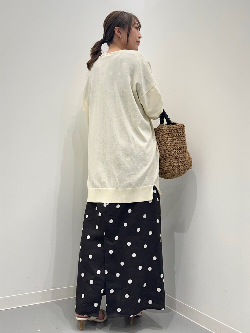 ブラック系のワンピース、ホワイト系のカーディガン/ボレロ、ベージュ系のかごバッグを着用したレディースの夏コーディネートの8枚目の写真