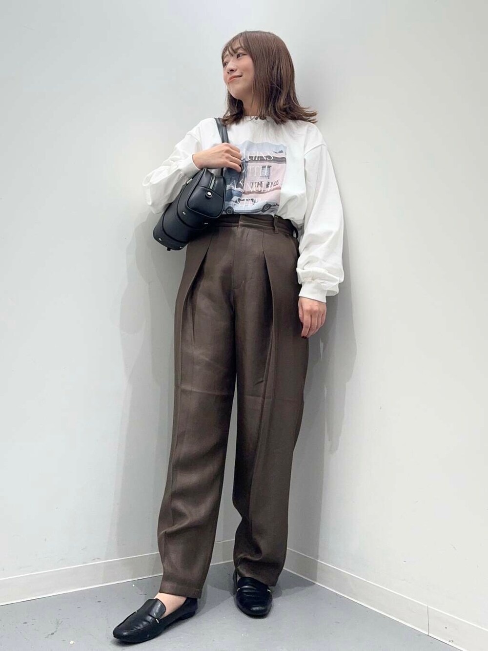 ブラック系のローファー、ブラック系のボストンバッグ、ブラウン系のその他パンツを着用したレディースの秋コーディネートの2枚目の写真