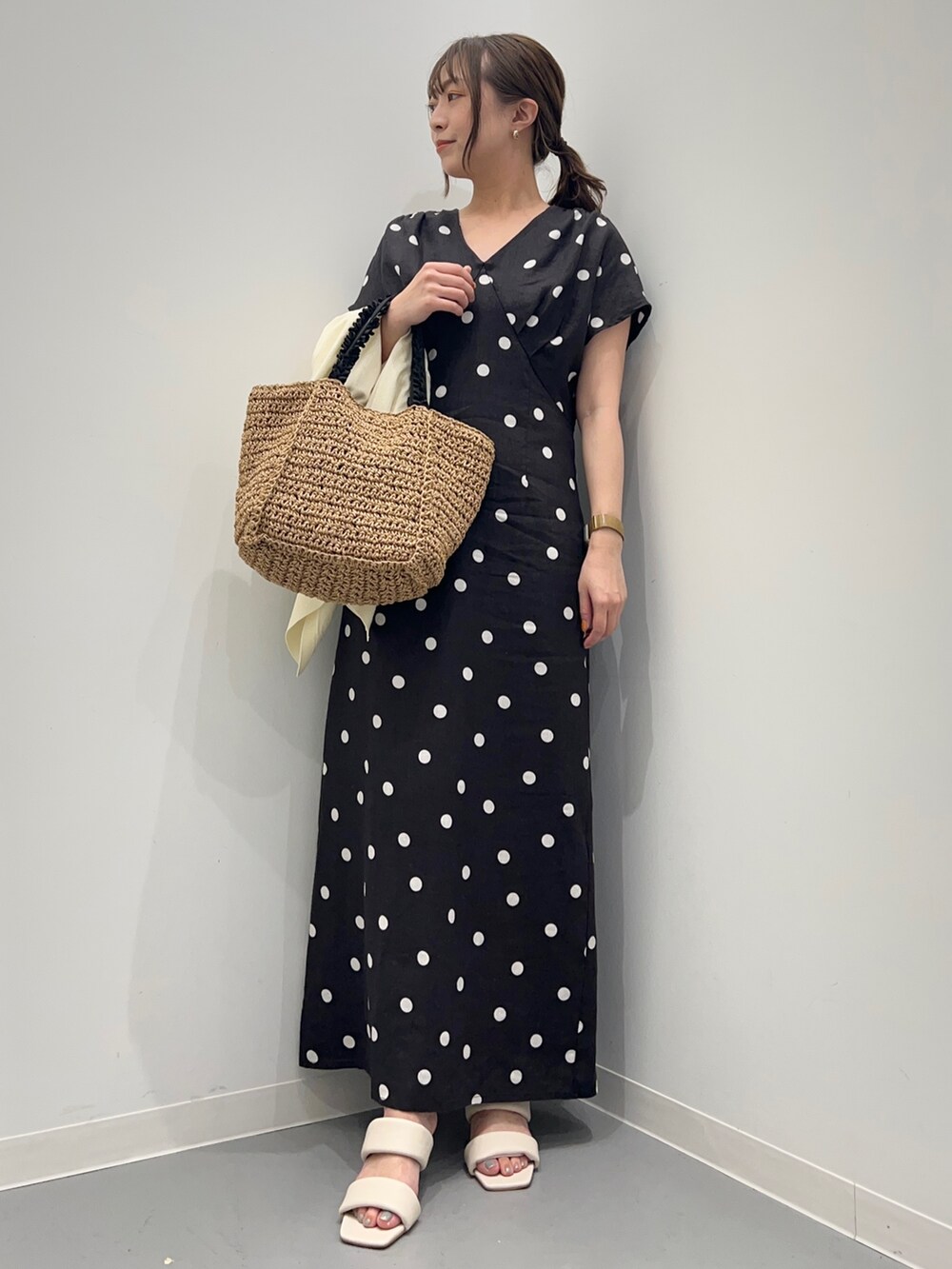 ブラック系のワンピース、ホワイト系のカーディガン/ボレロ、ベージュ系のかごバッグを着用したレディースの夏コーディネートの4枚目の写真