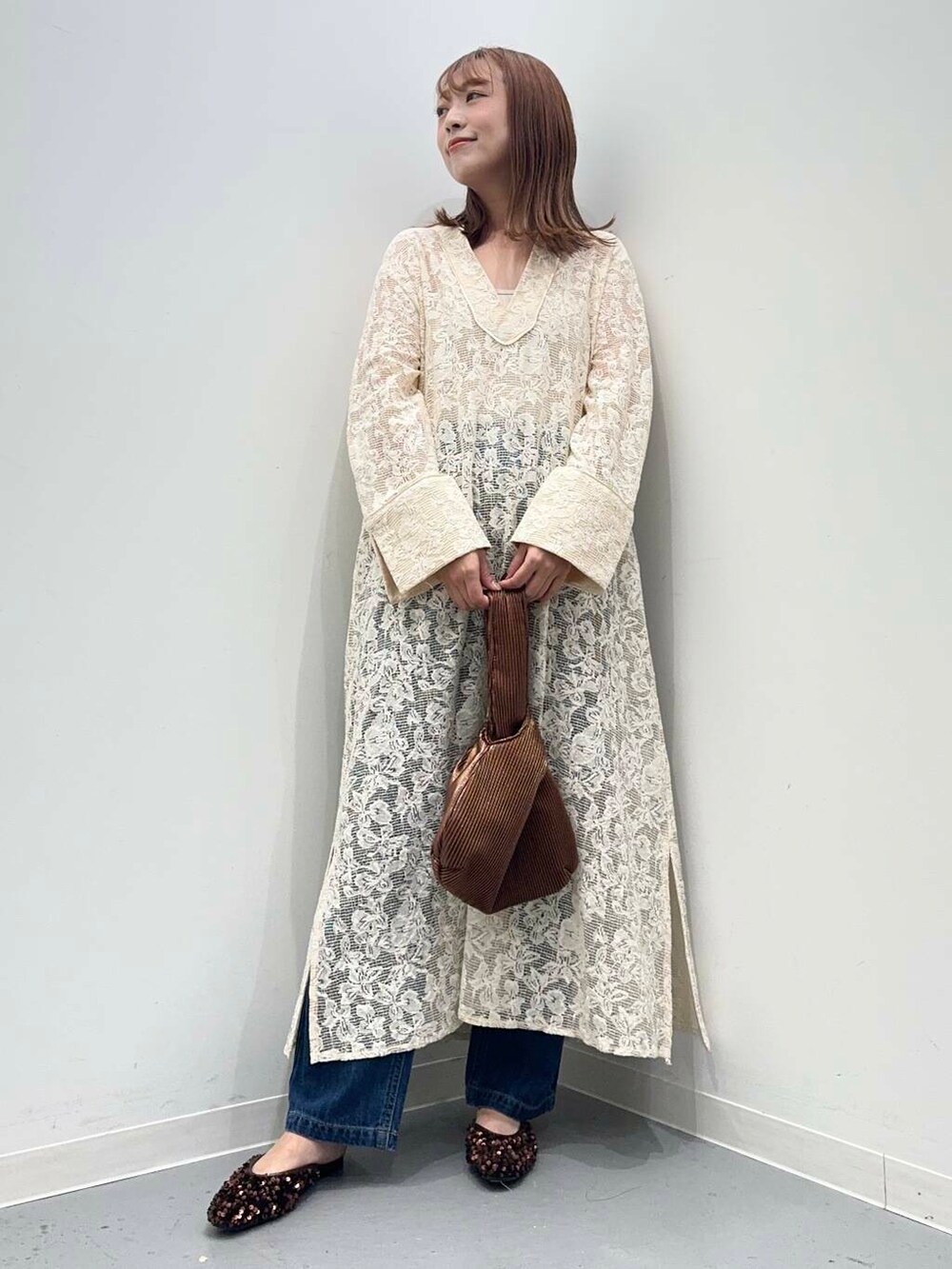 ブラウン系のハンドバッグ、ブルー系のデニムパンツ、ブラウン系のその他シューズを着用したレディースの秋コーディネートの5枚目の写真