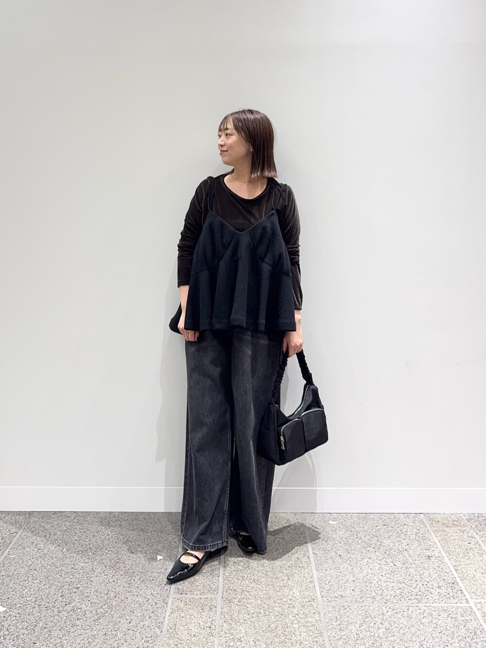 ブラック系のキャミソール、ブラウン系のTシャツ/カットソー、ブラック系のパンプスを着用したレディースの秋コーディネートの5枚目の写真