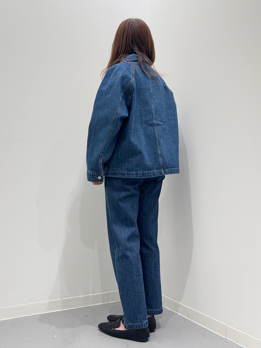 ブルー系のカバーオール、ブルー系のデニムパンツ、イエロー系のニット/セーターを着用したレディースの春コーディネートの4枚目の写真