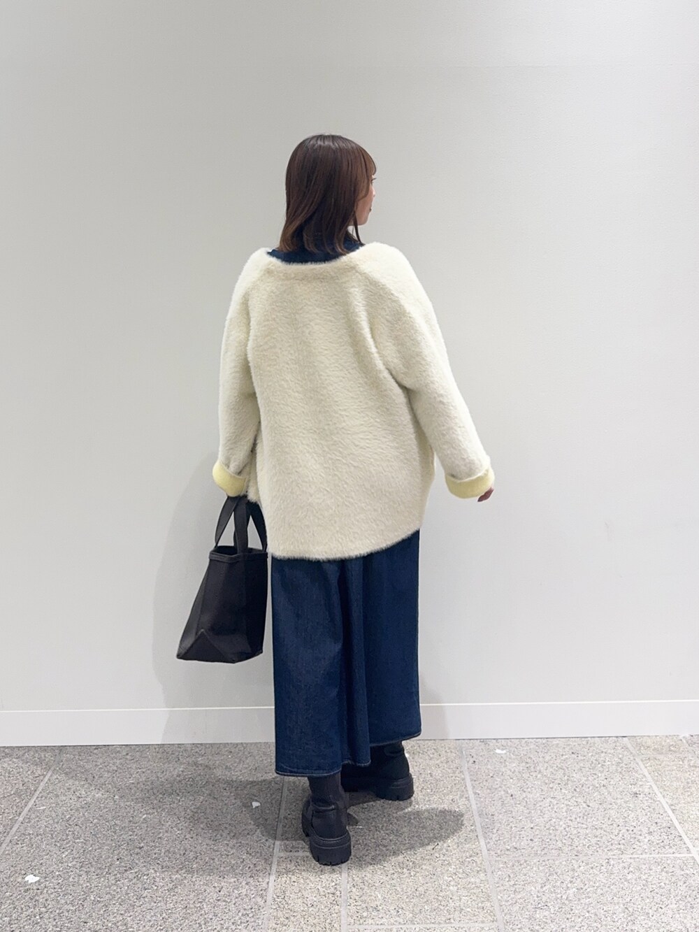 ブルー系のワンピース、ホワイト系のカーディガン/ボレロ、グレー系のトートバッグを着用したレディースの秋コーディネートの3枚目の写真