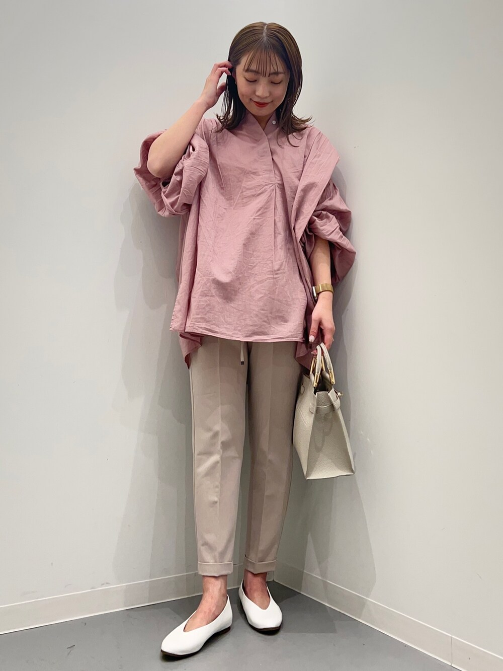 ピンク系のシャツ/ブラウス、ベージュ系のその他パンツ、ホワイト系のパンプスを着用したレディースの春コーディネートの3枚目の写真