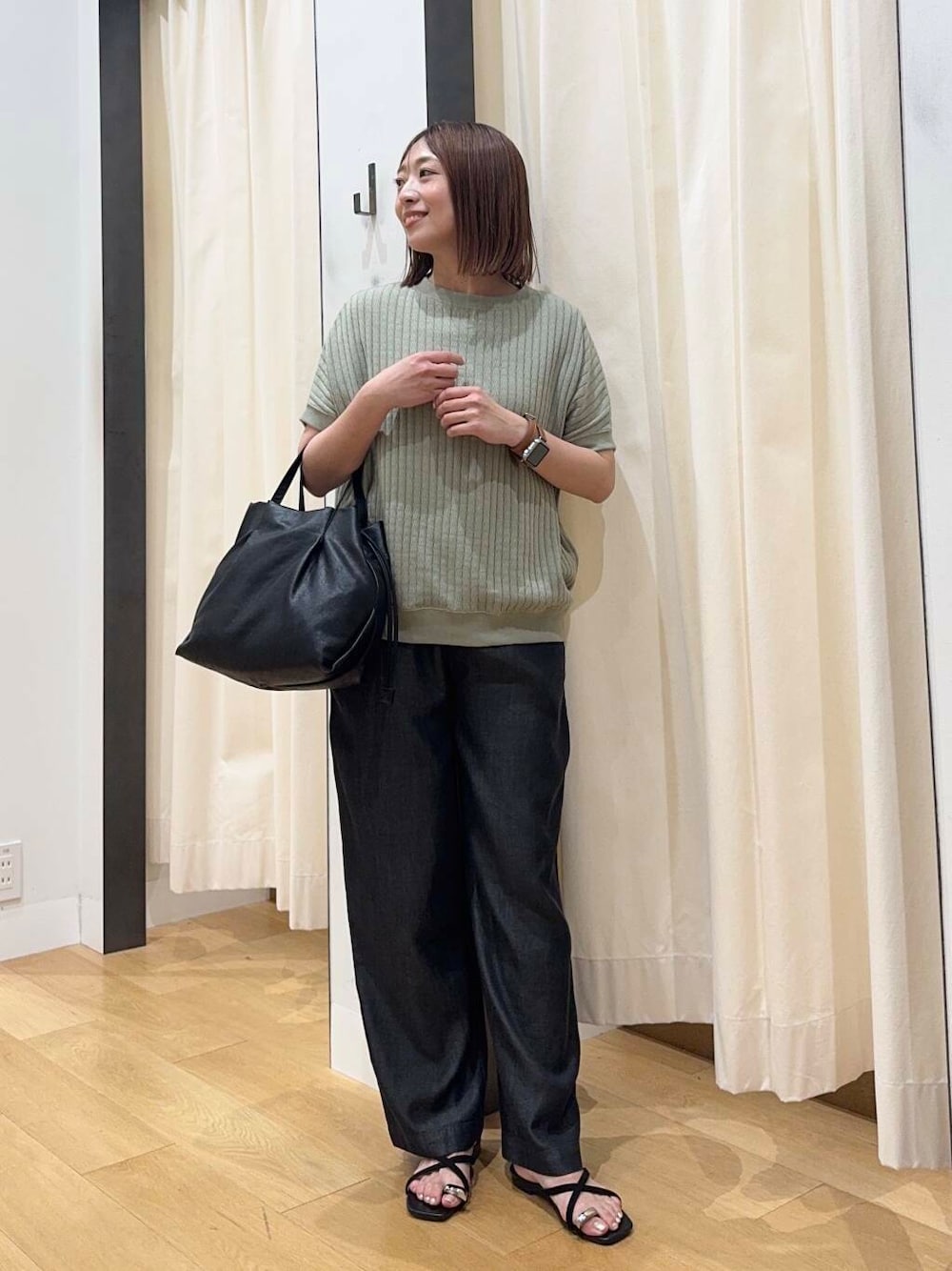 ブラック系のショルダーバッグ、ブラック系のデニムパンツ、グリーン系のTシャツ/カットソーを着用したレディースの夏コーディネートの4枚目の写真