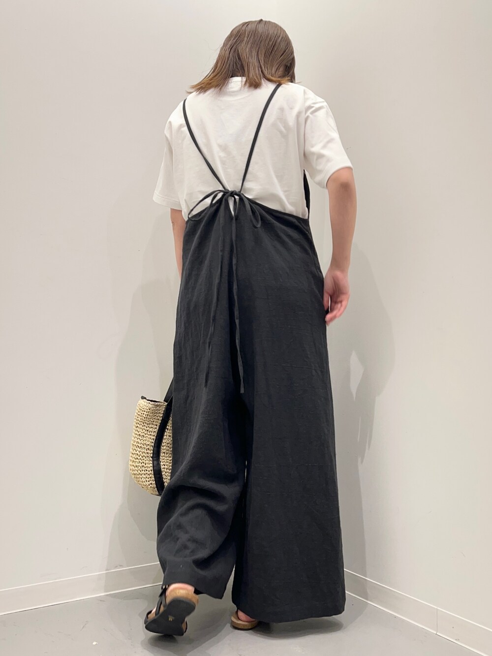 ホワイト系のTシャツ/カットソー、ブラック系のサロペット/オーバーオール、ブラック系のサンダルを着用したレディースの春コーディネートの6枚目の写真