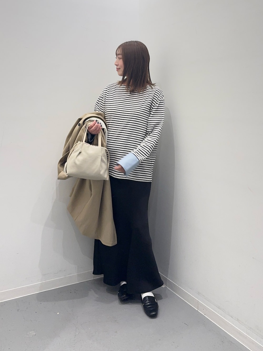 ベージュ系のその他アウター、ホワイト系のTシャツ/カットソー、ブラック系のスカートを着用したレディースの春コーディネートの6枚目の写真