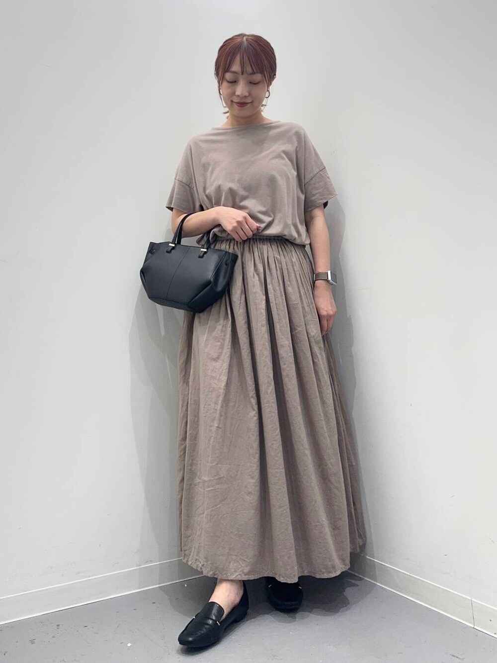 ブラック系のローファー、グレー系のワンピース、ブラック系のショルダーバッグを着用したレディースの夏コーディネートの3枚目の写真