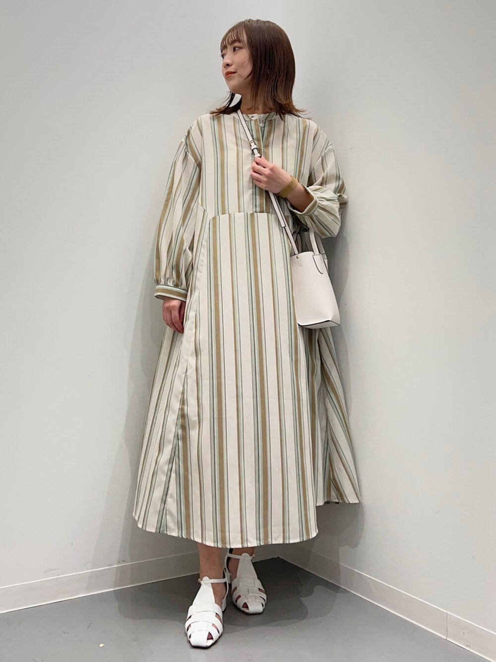 グリーン系のワンピース、ホワイト系のサンダルを着用したレディースの春コーディネートの2枚目の写真