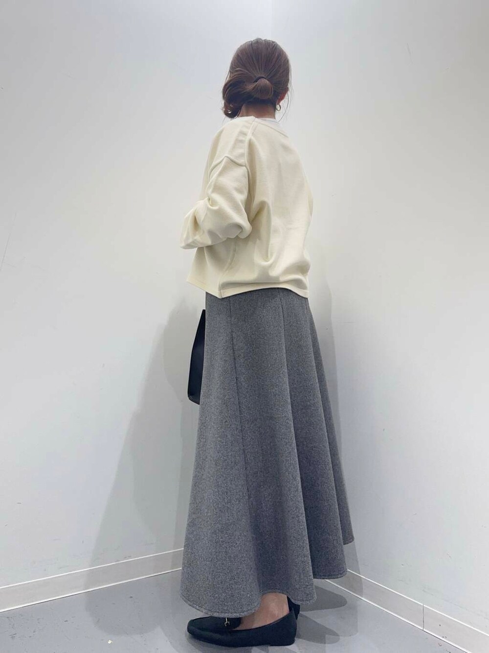ホワイト系のカーディガン/ボレロ、グレー系のスカート、ブラック系のトートバッグを着用したレディースの冬コーディネートの3枚目の写真