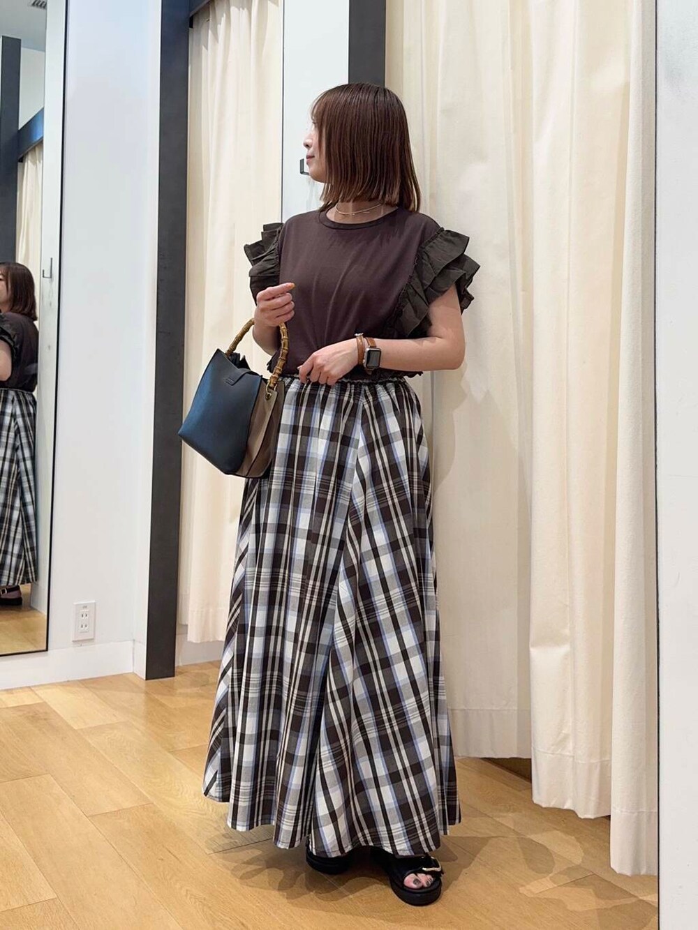 ブラック系のサンダル、ブラウン系のTシャツ/カットソー、ブラック系のハンドバッグを着用したレディースの夏コーディネートの2枚目の写真