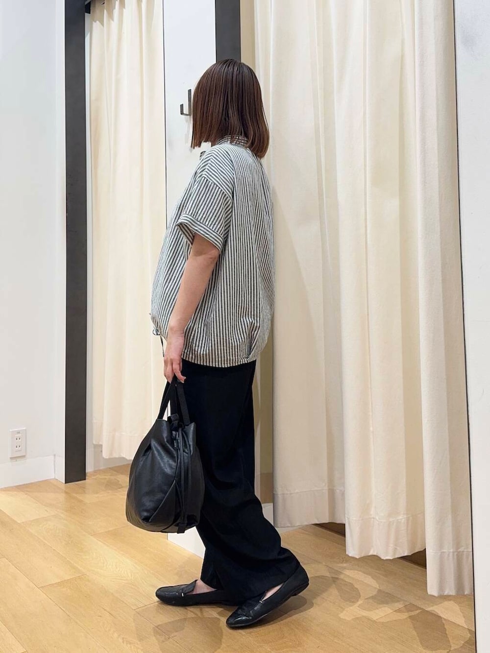 ブラック系のトートバッグ、ブラック系のその他パンツ、ブラック系のローファーを着用したレディースの夏コーディネートの3枚目の写真