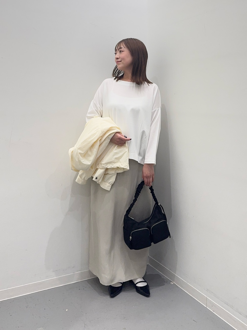 ホワイト系のナイロンジャケット、ベージュ系のスカート、ホワイト系のTシャツ/カットソーを着用したレディースの春コーディネートの7枚目の写真