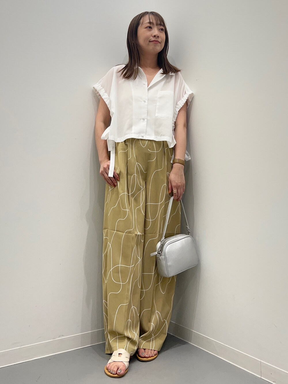 ホワイト系のシャツ/ブラウス、ベージュ系のその他パンツ、ホワイト系のサンダルを着用したレディースの夏コーディネートの2枚目の写真