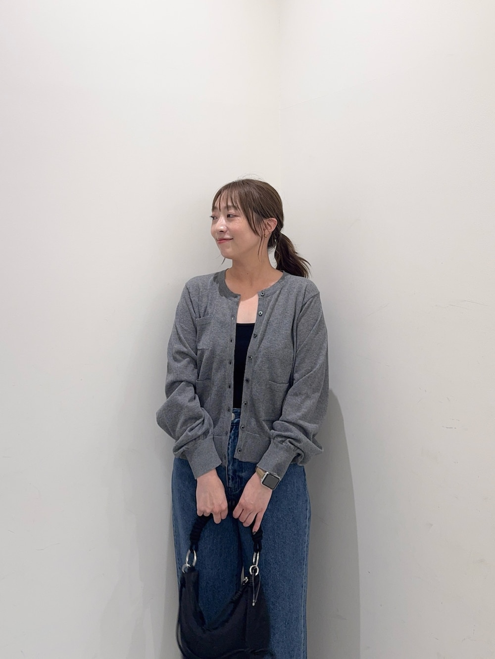 グレー系のカーディガン/ボレロ、ブルー系のデニムパンツ、ブラック系のハンドバッグを着用したレディースの夏コーディネートの6枚目の写真