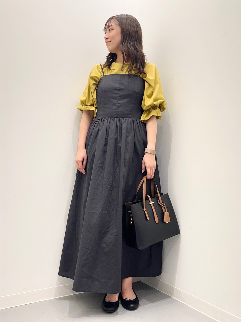 グレー系のワンピース、イエロー系のTシャツ/カットソーを着用したレディースの夏コーディネートの2枚目の写真