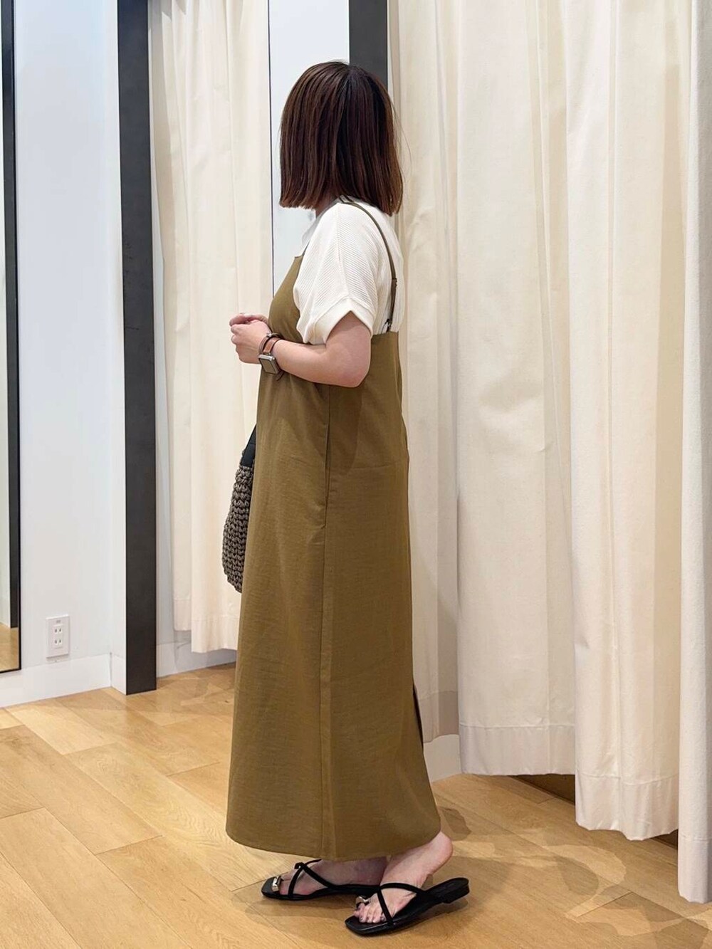 グレー系のトートバッグ、ベージュ系のTシャツ/カットソー、ブラック系のサンダルを着用したレディースの夏コーディネートの3枚目の写真