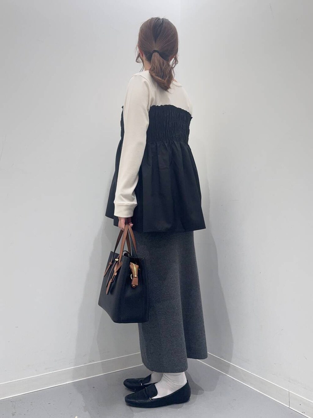 ブラック系のローファー、ブラック系のトートバッグ、ホワイト系のTシャツ/カットソーを着用したレディースの冬コーディネートの3枚目の写真