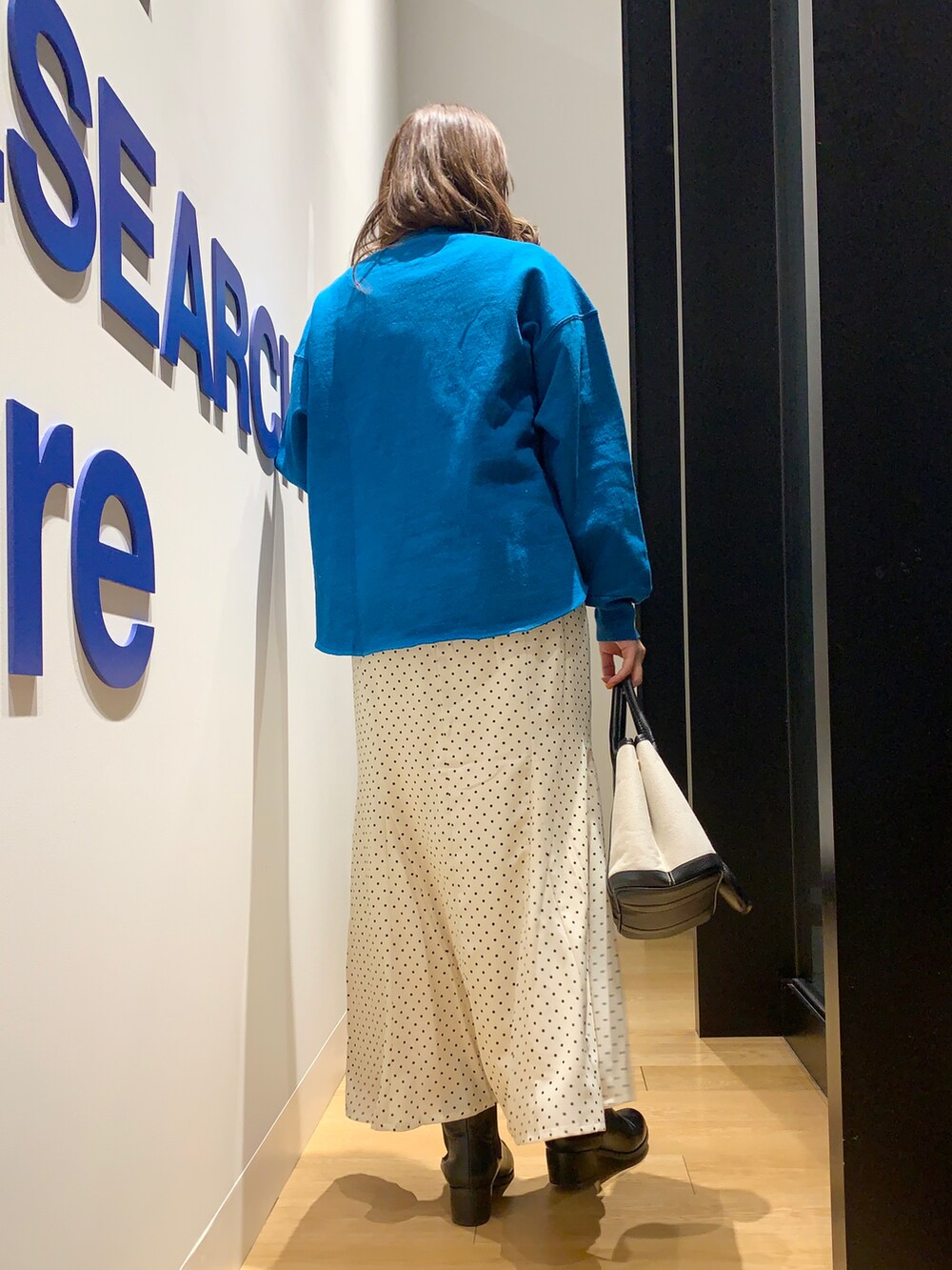 ブルー系のスウェット、ホワイト系のスカートを着用したレディースの冬コーディネートの4枚目の写真