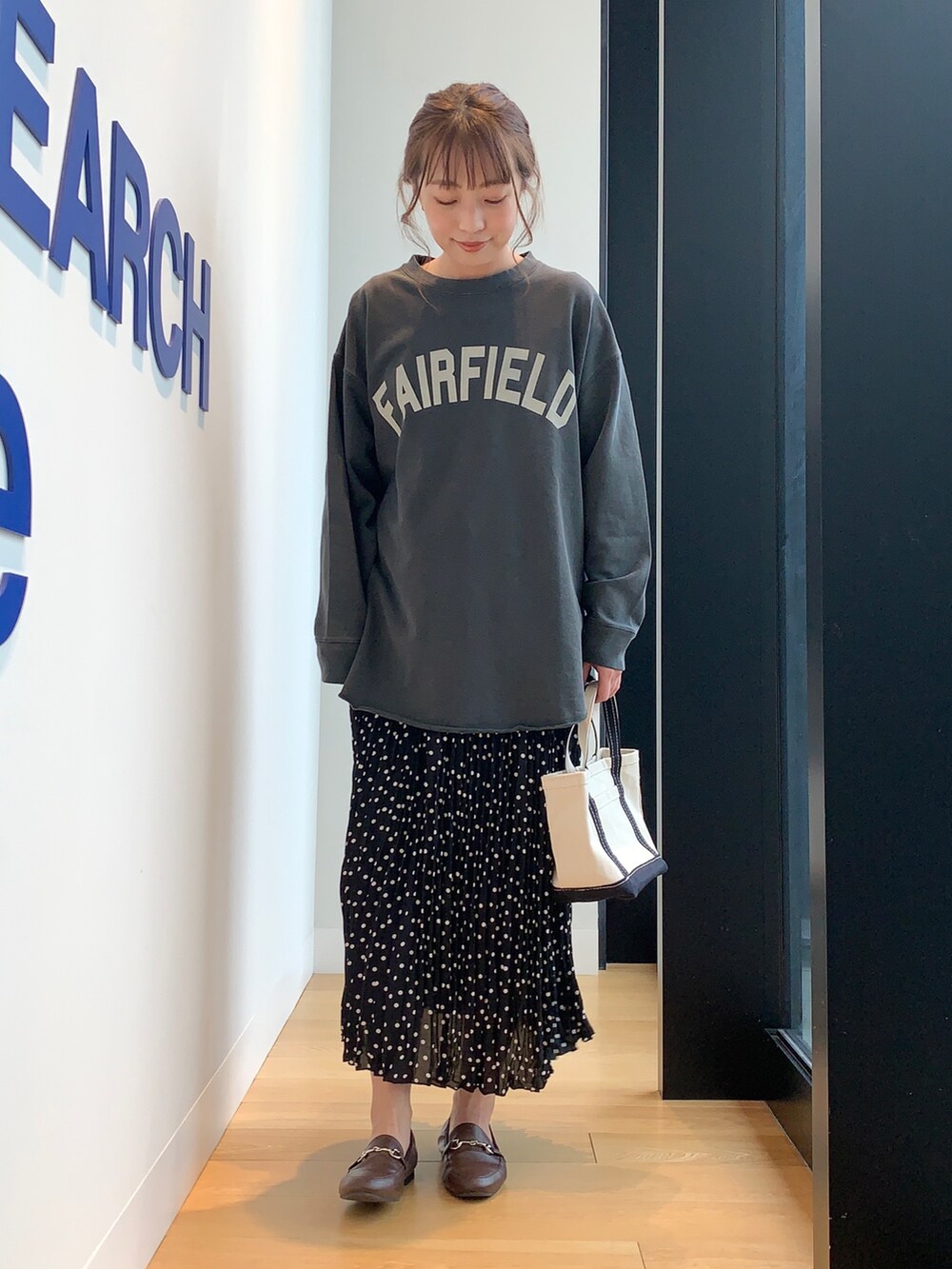 ブラック系のTシャツ/カットソー、ブラック系のスカート、ブラウン系のローファーを着用したレディースの冬コーディネートの4枚目の写真