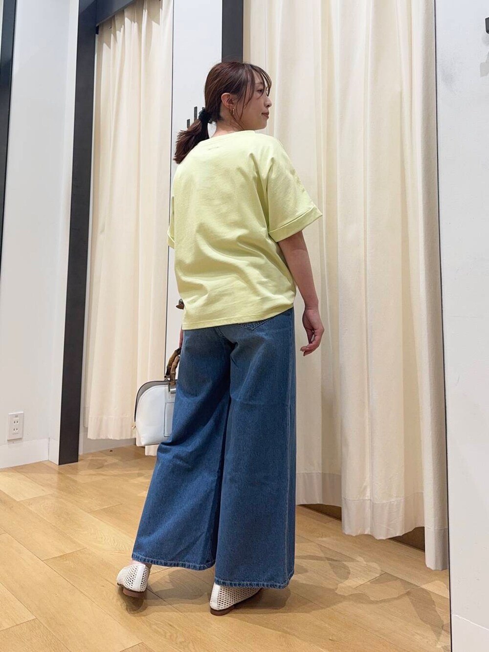 ホワイト系のバレエシューズ、イエロー系のTシャツ/カットソー、ホワイト系のハンドバッグを着用したレディースの夏コーディネートの4枚目の写真